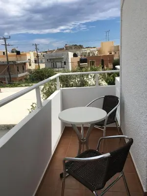 a table and two chairs on a balcony with a view at Studios George in Palaiochóra