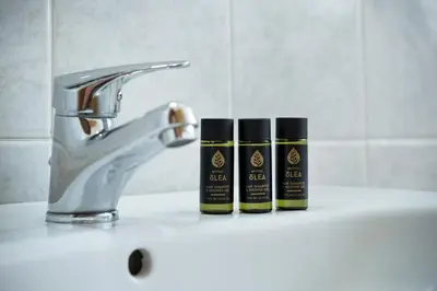 two bottles of soap sitting on a sink next to a faucet at Kalami Apartments in Falasarna