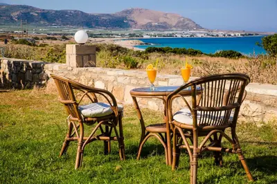 two chairs and a table with two glasses of orange juice at Kalami Apartments in Falasarna