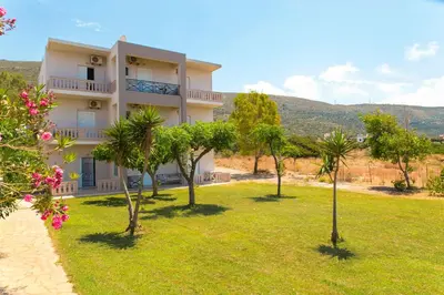 a house with palm trees in front of it at Kalami Apartments in Falasarna