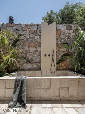 a stone wall with a bathtub in front of it at Elafonisi Villas in Livadia