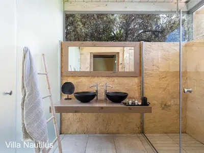 a bathroom with two sinks and a mirror at Elafonisi Villas in Livadia