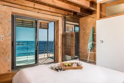 a bedroom with a bed and a view of the ocean at Elafonisi Villas in Livadia