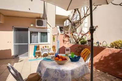 a table with a bowl of fruit and an umbrella at Backyard Art Studio in Chania Town