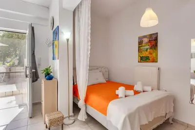 a bedroom with a bed with an orange blanket at Backyard Art Studio in Chania Town