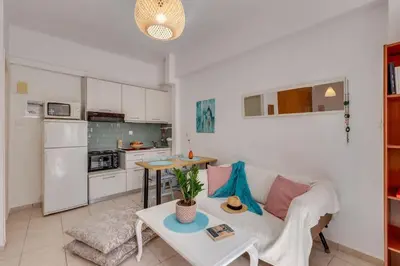 a living room with a white couch and a table at Backyard Art Studio in Chania Town