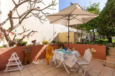 a table with an umbrella and a table and chairs at Backyard Art Studio in Chania Town