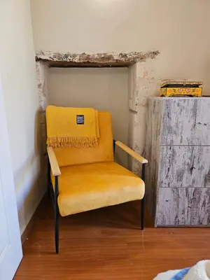 a chair with a yellow blanket sitting in a room at Casa Stella in Chania Town