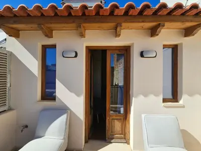 two chairs in front of a house with a door at Casa Stella in Chania Town