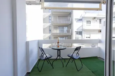 a table and chairs on a balcony with a building at Cozy Apartment 50m to beach, 5min walk to Old Town in Chania Town
