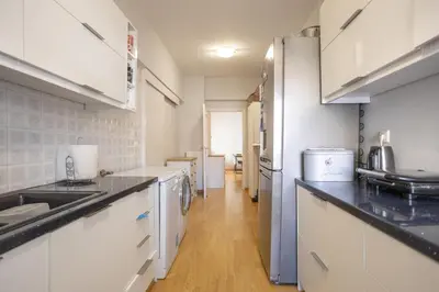 a kitchen with white cabinets and a refrigerator at Cozy Apartment 50m to beach, 5min walk to Old Town in Chania Town