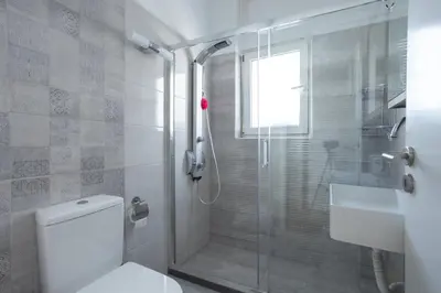 a bathroom with a shower and a toilet and a sink at Cozy Apartment 50m to beach, 5min walk to Old Town in Chania Town