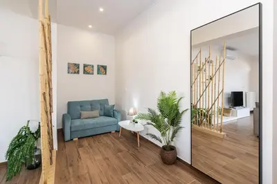 a living room with a blue couch and a mirror at Galanidis Luxury Apartments in Perivólia