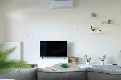a living room with a couch and a flat screen tv at Galanidis Luxury Apartments in Perivólia