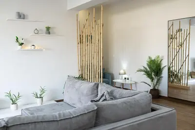 a living room with a gray couch and a mirror at Galanidis Luxury Apartments in Perivólia