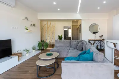 a living room with a gray couch and a table at Galanidis Luxury Apartments in Perivólia