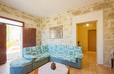a living room with a blue couch and a table at Levendi's House in Kissamos
