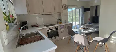 a kitchen with a sink and a table with chairs at Christos in Kissamos