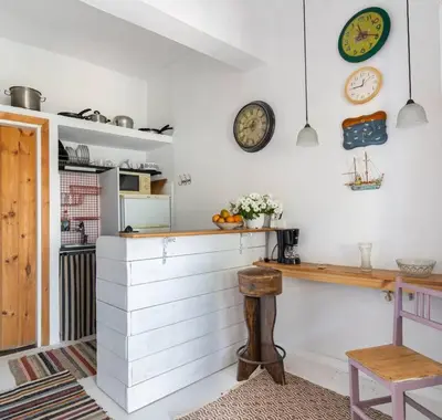 a kitchen with a counter and clocks on the wall at Η αυλή της Ασπασίας, Χανιά Κρήτη in Lákkoi
