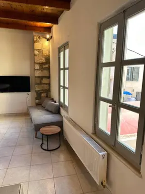 a living room with a couch and two windows at Casa Di Sarpaki in Chania Town