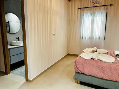a bedroom with a bed and a sink and a mirror at Roussos Place - Next To Splantzia Square - 2bd 2ba in Chania Town