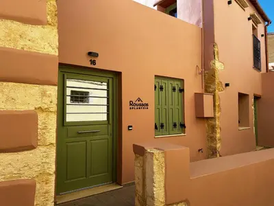 a green door on the side of a building at Roussos Place - Next To Splantzia Square - 2bd 2ba in Chania Town