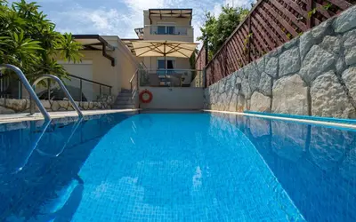 a large blue swimming pool next to a building at The Seaside Villa in Chania Town
