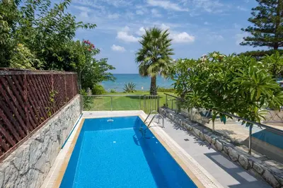 a swimming pool with a view of the ocean at The Seaside Villa in Chania Town