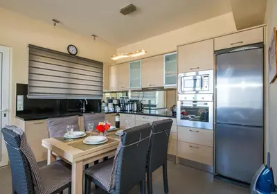 a kitchen with a wooden table and a stainless steel refrigerator at The Seaside Villa in Chania Town