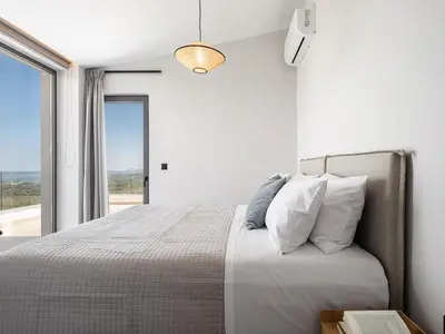 a bedroom with a bed and a large window at Villa Levante With Sea View in Plataniás