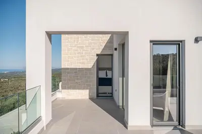a glass door leading to a balcony with a view at Villa Zefyros With Sea View in Plataniás