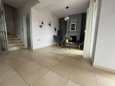 a living room with a tile floor and a table at Ion villa - Xirokampi in Ayiá