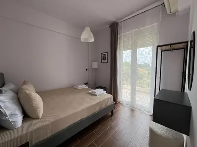 a bedroom with a bed and a large window at Ion villa - Xirokampi in Ayiá