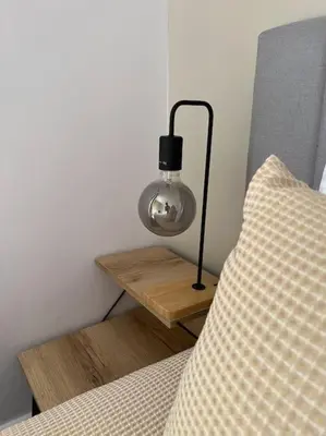 a lamp on a night stand next to a bed at Ion villa - Xirokampi in Ayiá