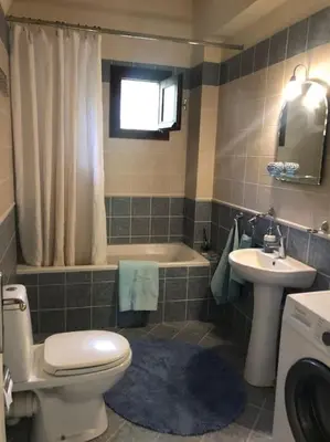 a bathroom with a toilet and a sink and a tub at Villa Europa Ravdoucha Private Pool and Amazing View in Ravdhoúkha