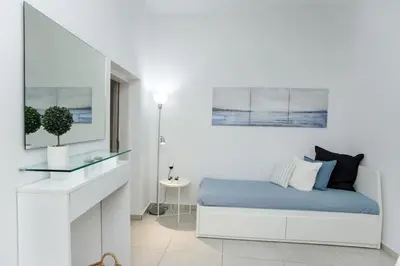 a white bedroom with a bed and a desk at Modern House in the Old Town in Chania Town