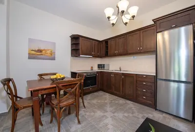 a kitchen with a wooden table and a stainless steel refrigerator at Villa Olivia in Chania Town