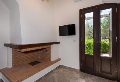 a room with a fireplace with a television and a door at Villa Olivia in Chania Town