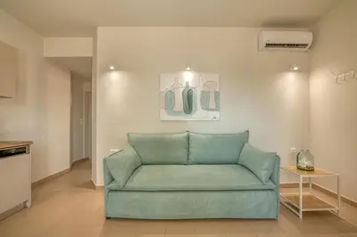 a green couch in a living room with a table at Koutris Apartment 1 in Falasarna