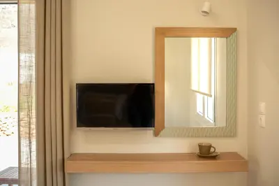 a bathroom with a mirror and a tv on a wall at Koutris Apartment 1 in Falasarna