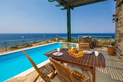 a table and chairs on a patio with a view of the ocean at Amazing sea views at villa Elafonissi with private pool, near Elafonissi beach in Chania Town