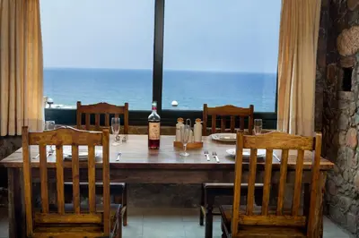 a table with chairs and a bottle of wine on it at Amazing sea views at villa Elafonissi with private pool, near Elafonissi beach in Chania Town