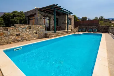 a swimming pool in front of a stone house at Amazing sea views at villa Elafonissi with private pool, near Elafonissi beach in Chania Town