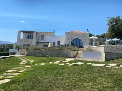 a large house with a grassy yard in front of it at Villa Annie Crete - Private Luxury Villa with Sea and Mountain Views in Tsivarás