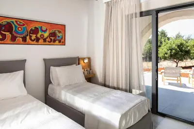 two beds in a room with a view of a patio at Villa Annie Crete - Private Luxury Villa with Sea and Mountain Views in Tsivarás