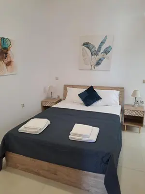 a bedroom with a bed with two towels on it at Olea Homes in Plátanos