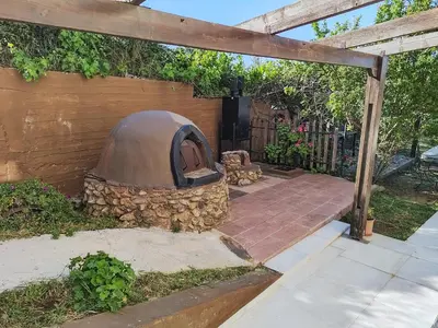 a garden with an outdoor oven in a backyard at Rododafni Apartments in Kolymvari