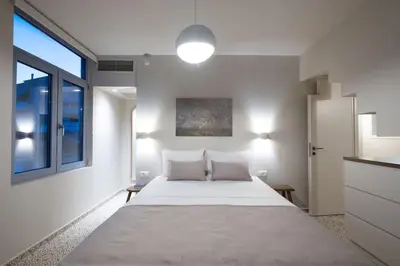 a white bedroom with a large bed and a window at Once Upon a Home in Chania Town
