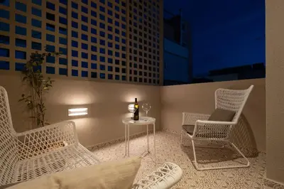 a patio with white chairs and a table with a candle at Once Upon a Home in Chania Town
