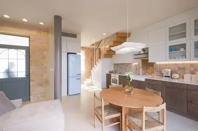 a kitchen with a table and chairs in a room at Once Upon a Home in Chania Town